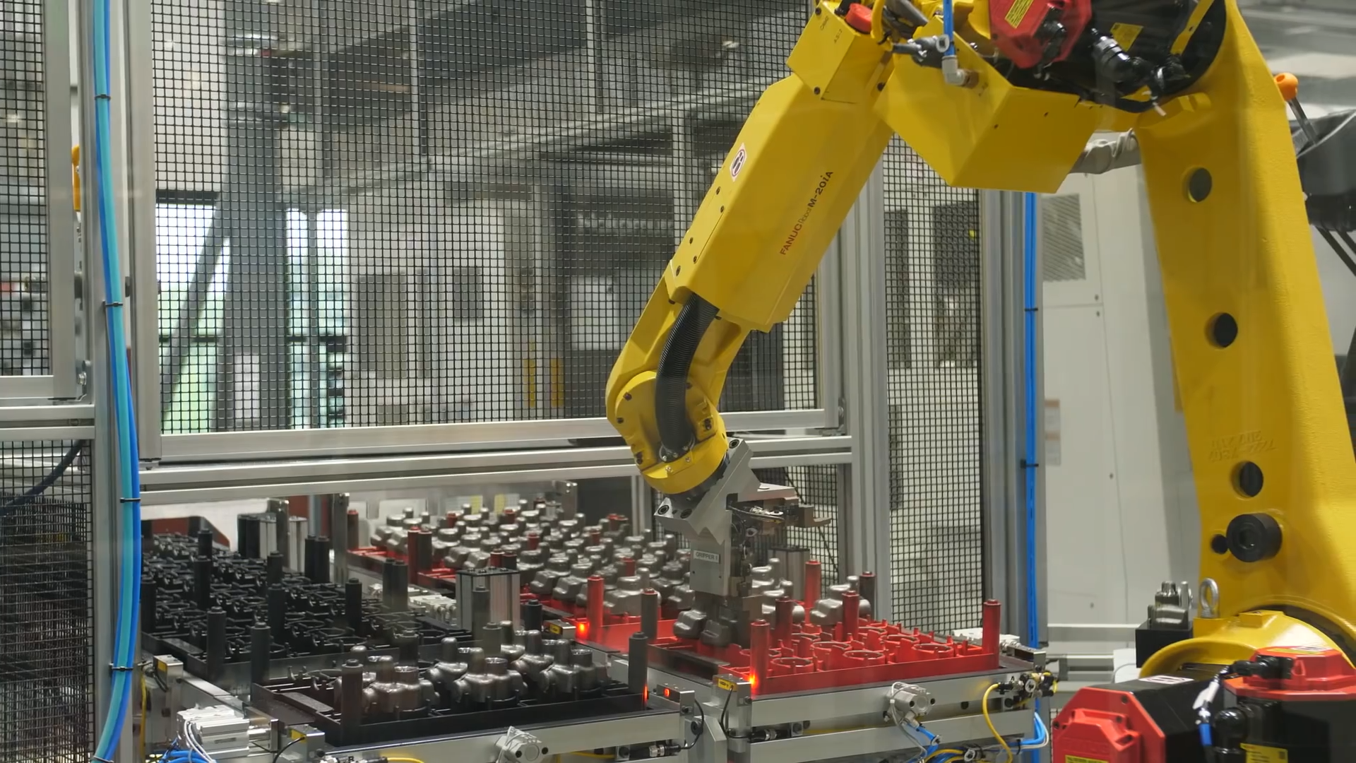 FANUC robot arm stacking trays in a custom robotics cell